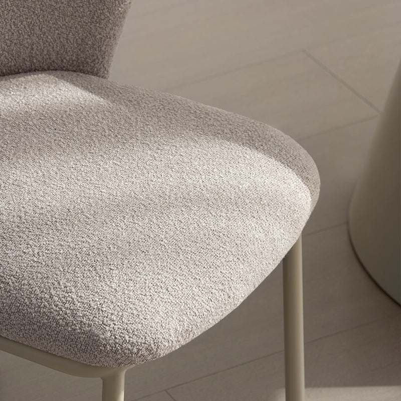 Karin Esszimmerstuhl in Beige – moderner Bouclé-Stoff mit breiter Rückenlehne und pulverbeschichteten Metallbeinen. Ideal für Esszimmer oder Homeoffice.